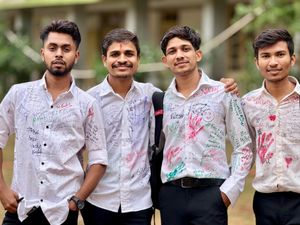 Group of young men with autographed shirts celebrating together outdoors.
